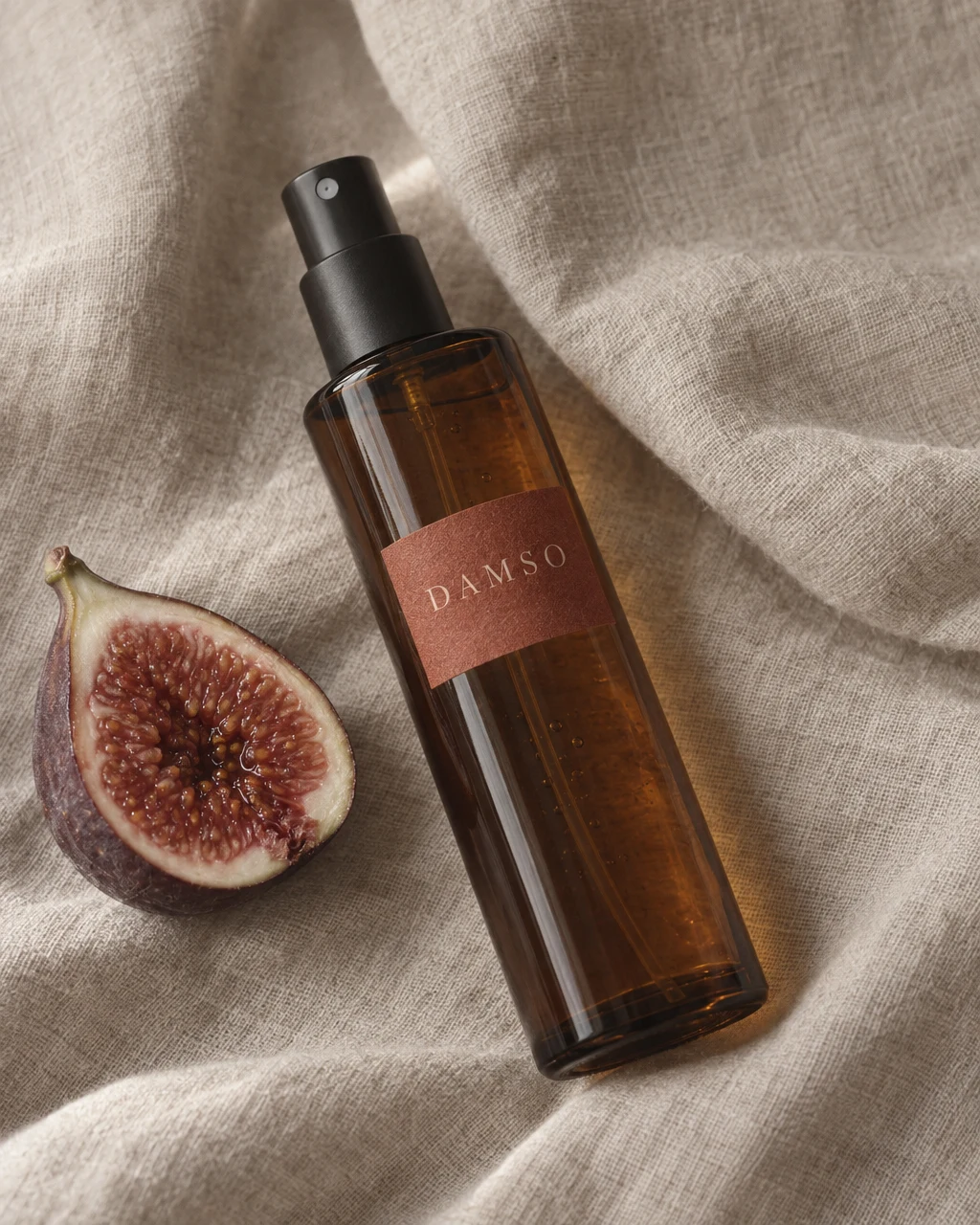 DAMSO room spray and a halved fig on linen