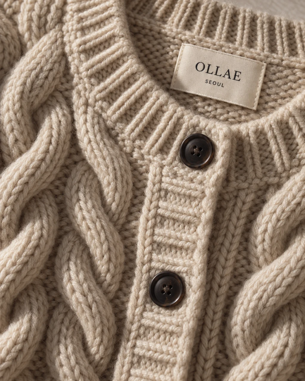 The OLLAE cable cardigan's knit and label, close up