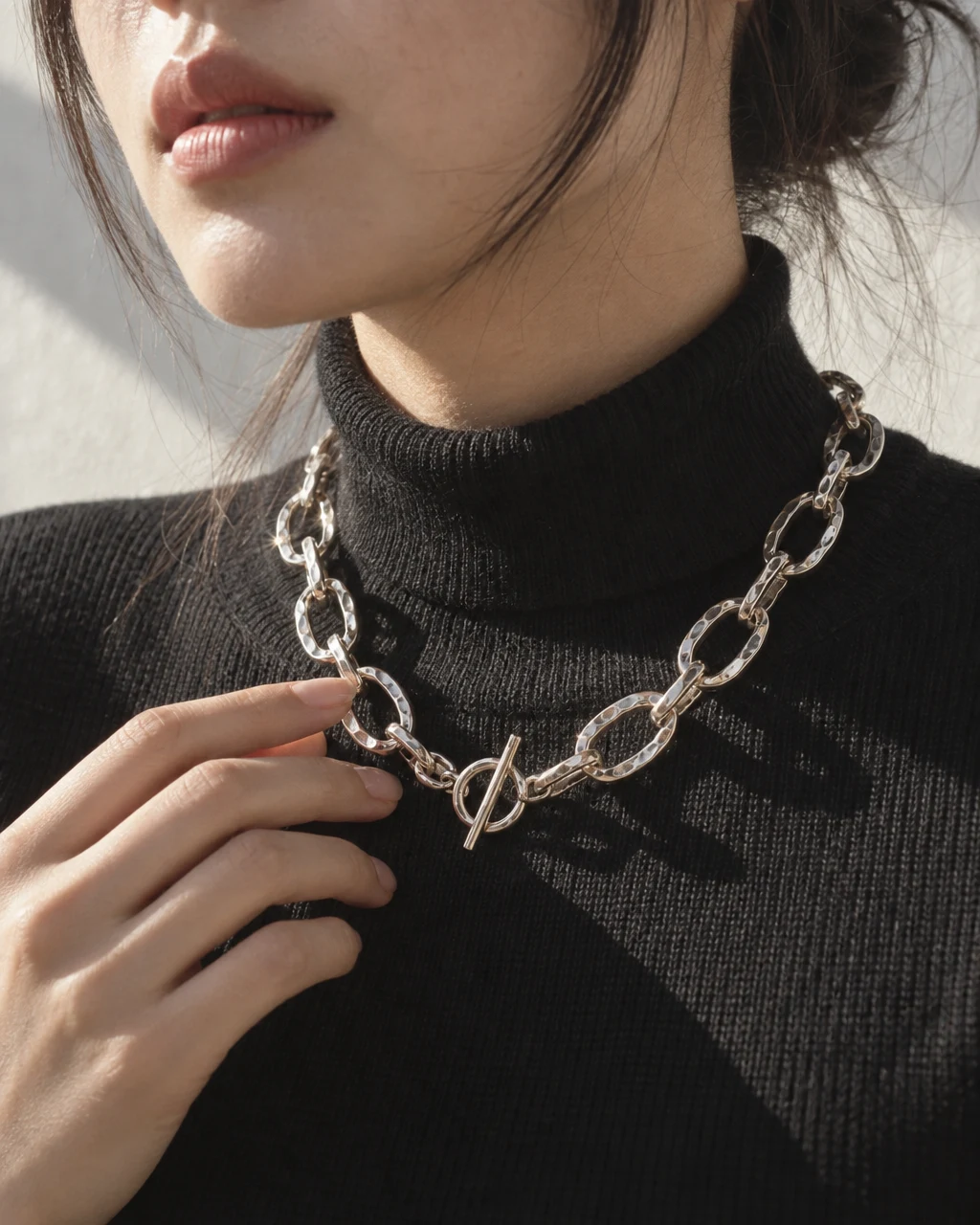 The SEOL silver chain necklace over a black turtleneck